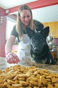 Nicole Sztabkowski and her German Shepherd Lexi with a recently completed batch of dog treats. Photo By Matt Preprost