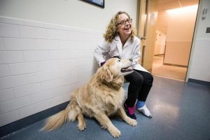 Dr. Cheryl London shares a moment with Drambuie. His participation in a clinical trial saved him from cancer.