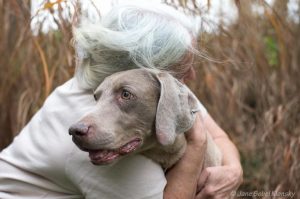old person hugging dog